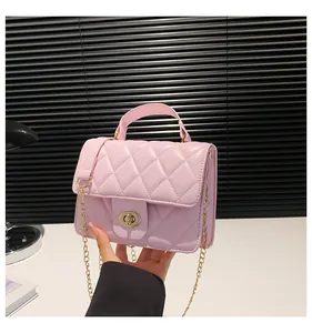 Detailed close-up of pink quilted crossbody bag with gold chain and metal twist lock