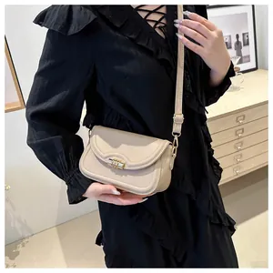 Detail showing creamy beige PU leather texture and golden cylindrical twist lock closure