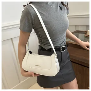 Chic white leather shoulder bag shown on a model with a clean minimalist indoor background