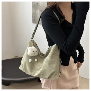 Close-up of light green nylon tote bag with pleated texture and white cloud plush charm