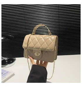 Close-up of quilted beige crossbody bag with gold hardware and twist-lock clasp