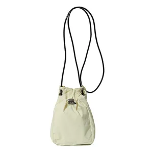 Minimalist beige drawstring crossbody bag with black rope strap on white background