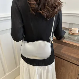 Silver metallic crescent crossbody bag with bow detail and chain strap for women