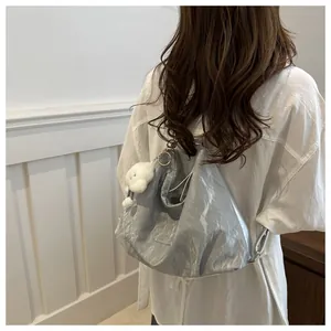 Silver metallic hobo bag with cloud charm shown on shoulder of a white shirt model