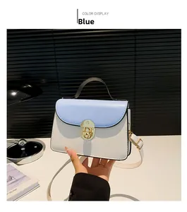 Dettaglio della borsa a tracolla bicolore con elegante chiusura a scatto dorata