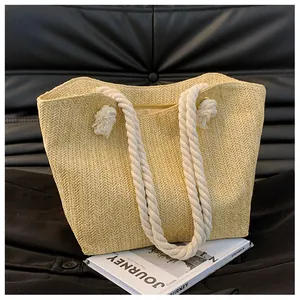 Detailed V-weave pattern of large straw tote bag with white cotton rope handles