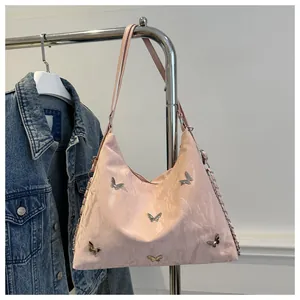 Detail view of pink satin shoulder bag with silver metallic butterfly ornaments and chain