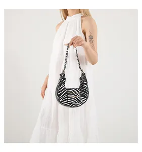 Detail of hobo shoulder bag with zebra print pattern and elegant gold buckle