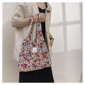 Détail du sac cabas en toile à fleurs montrant l'étiquette EMIS et le motif floral