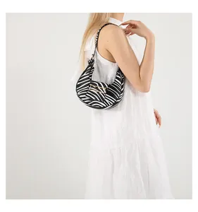 Detail of a zebra print half-moon underarm bag with sleek gold buckle and PU leather strap