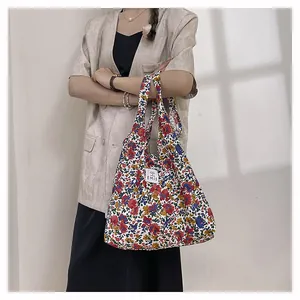 Détail du sac cabas EMIS en toile fleurie avec étiquette tissée et motifs floraux rétro
