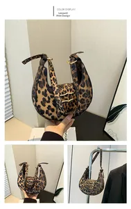 Detail view of leopard print crescent bag with adjustable buckle strap and gold hardware