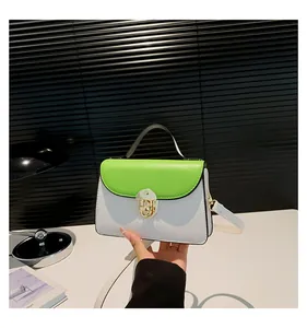 Dettaglio borsa bicolore con patta verde neon e chiusura a girello in metallo oro