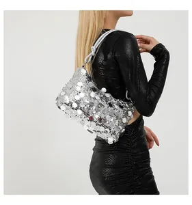 Detail of silver sequin shoulder bag featuring a knotted strap and metallic finish