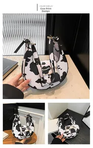 Detail of half-moon shoulder bag with cow print pattern and golden metal buckle