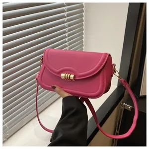 Close-up of pink square shoulder bag with gold metal buckle and stitching detail