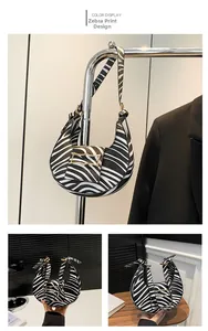 Detailed view of black and white zebra pattern handbag with elegant gold metal buckle