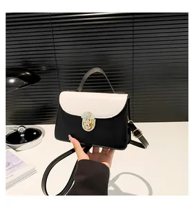 Dettaglio della piccola borsa quadrata a contrasto bianco e nero con chiusura girevole