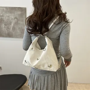 Stylish cream butterfly tote backpack with metallic ornaments for chic daily casual wear
