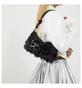 Detail of black sequined hobo bag featuring a knotted leather strap and half-moon design
