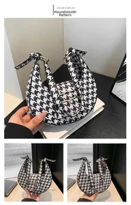 Detailed view of houndstooth crescent shoulder bag with golden hardware and adjustable knot