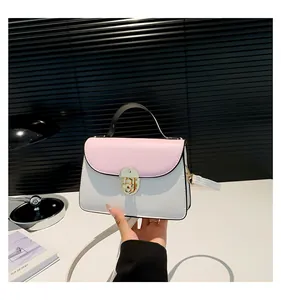 Dettaglio della borsa a tracolla bicolore rosa e bianca con chiusura girevole dorata