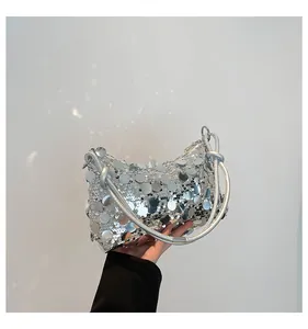 Detail of silver sequin handbag with large reflective discs and modern rope handle