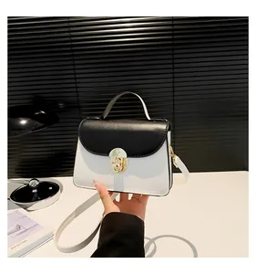 Dettaglio della piccola borsa quadrata bicolore bianco e nero con chiusura dorata