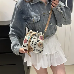 Close-up of ethnic style bucket bag with colorful floral tapestry and brown leather strap