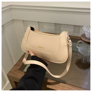 Detailed view of a creamy beige crescent shoulder bag made of high-quality faux leather