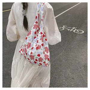 Détail du sac cabas en toile fleurie blanche avec motifs roses et étiquette tissée
