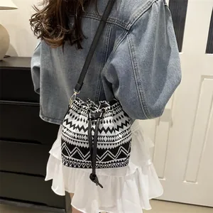 Detail of bohemian bucket bag with black and white geometric weaving and drawstring