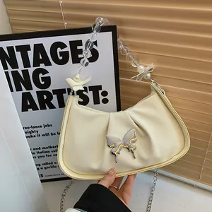 Sac bandoulière plissé beige avec anse perle et boucle papillon argentée élégante