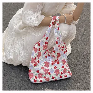 Détail du sac cabas en toile à fleurs avec roses roses et étiquette de marque EMIS