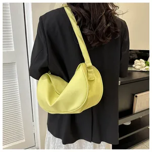 Detailed back view of a minimalist lime green crescent bag on a black blazer
