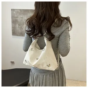 Close-up of white tote bag featuring unique pleated texture and 3D silver metal butterflies