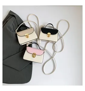 Tre mini borse a tracolla alla moda in beige, nero e rosa con chiusure dorate