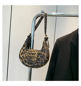 Detail of hobo bag with leopard print finish and wavy gold metallic hardware buckle