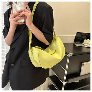Lime yellow moon bag with pebbled texture shown as a stylish crossbody on a model