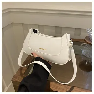 Close-up of white half-moon shoulder bag with sleek PU leather and gold logo detail