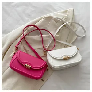 Detail of pink and white patent leather crossbody bags with golden cylindrical metal buckles
