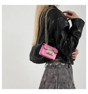 Détail du mini sac à bandoulière rose avec chaîne dorée et fermoir métallique