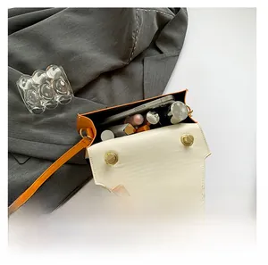 Interior view showing the storage capacity of the orange and beige leather crossbody bag