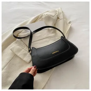 Detailed close-up of the black leather handbag texture and gold printed brand lettering