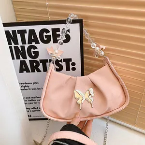 Sac bandoulière plissé rose avec boucle papillon argentée et chaîne de perles