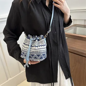 Ethnic style mini bucket bag with blue geometric pattern and tassel drawstring strap