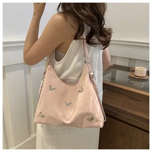 Detailed shot of pink pleated leather tote with decorative silver butterfly charms