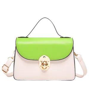 Piccola borsa quadrata minimalista in beige e verde a contrasto con chiusura dorata