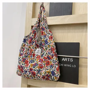 Détail du sac cabas en toile florale avec étiquette EMIS et motif de fleurs vintage