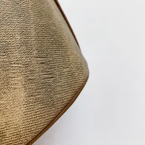 Detailed macro view of deep brown woven fabric texture with premium leather piping